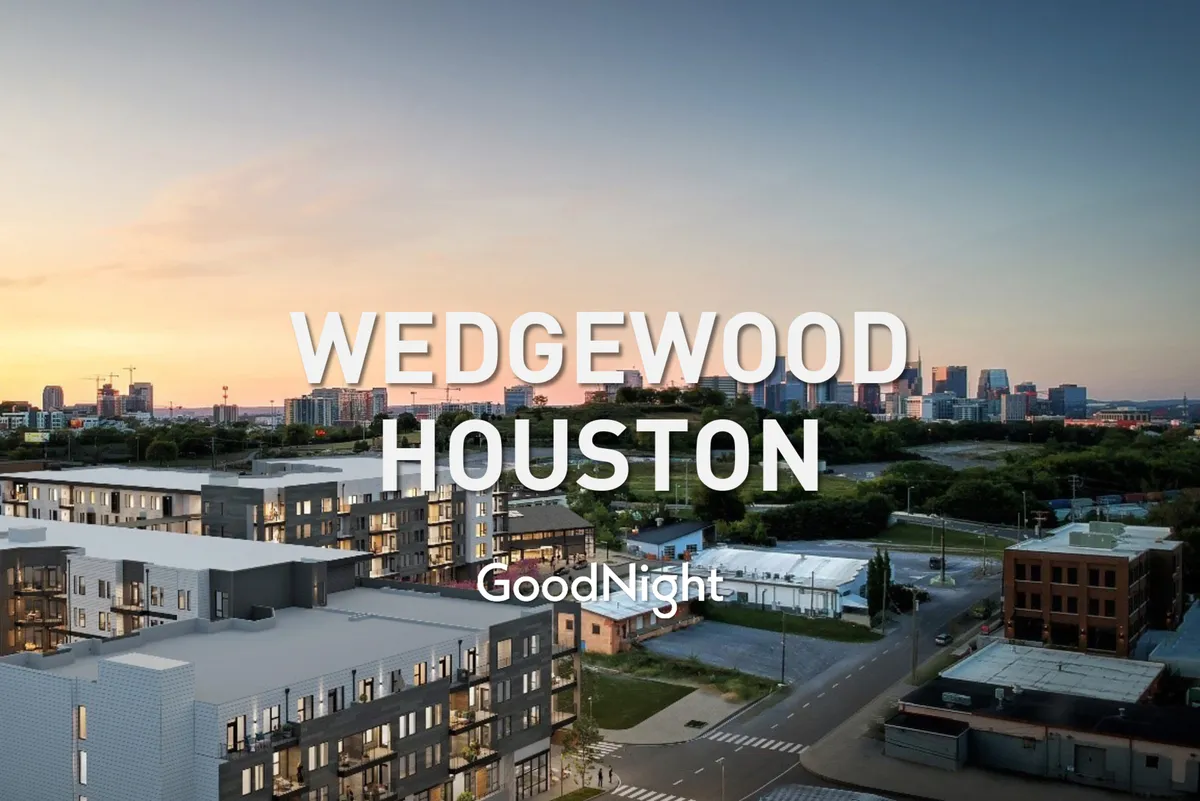 Modern apartment buildings with distant views of the Nashville city skyline and a lush, green landscape. The setting features community gathering spaces and balconies, suggesting a vibrant yet tranquil neighborhood atmosphere.