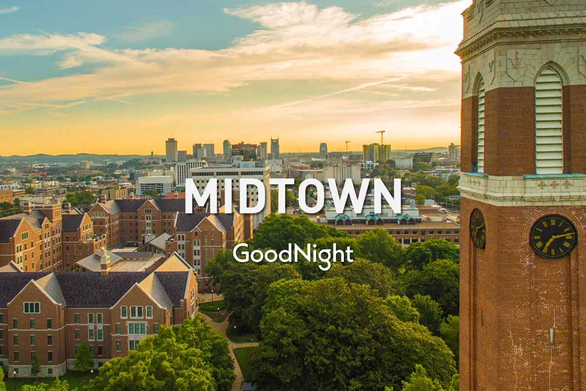 This image captures the city skyline at dusk, featuring historic architecture and lush green trees in the foreground. The lighting emphasizes a tranquil, atmospheric setting that invites viewers to imagine themselves gazing towards the city as the sun sets.